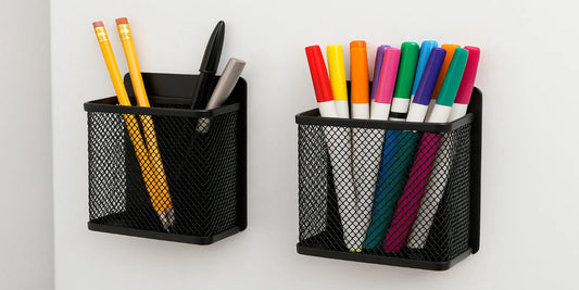 Two black mesh magnetic pencil holders on a white surface, one holding pencils and pens, the other filled with colorful markers neatly arranged.